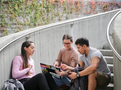 a photo of three students studying on stairs