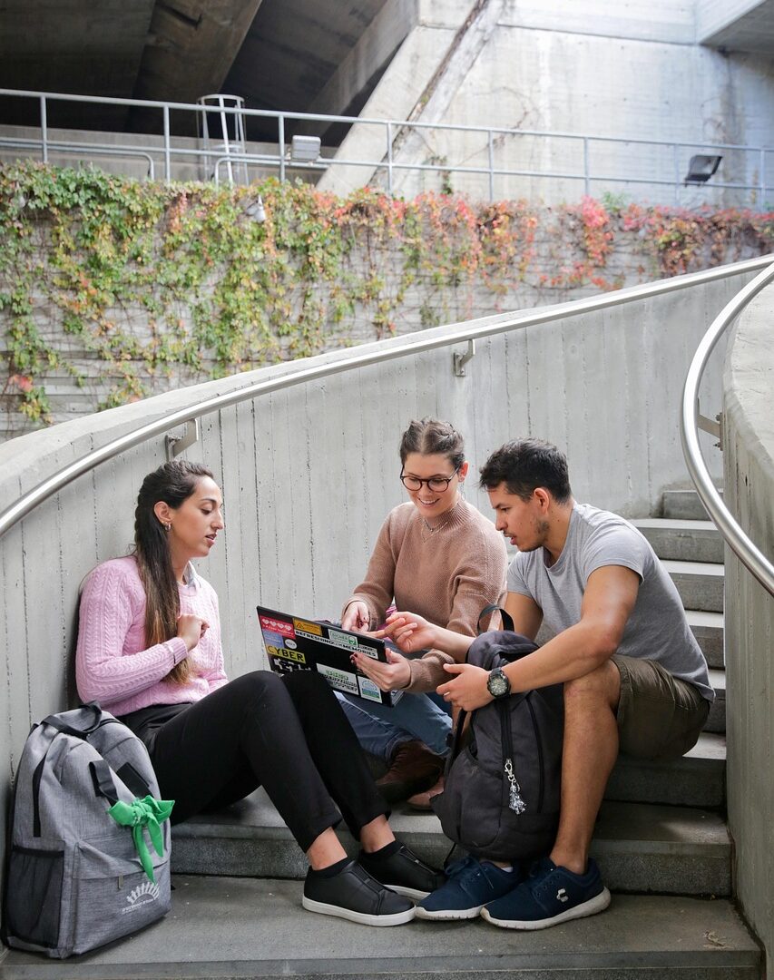 a photo of three students studying on stairs